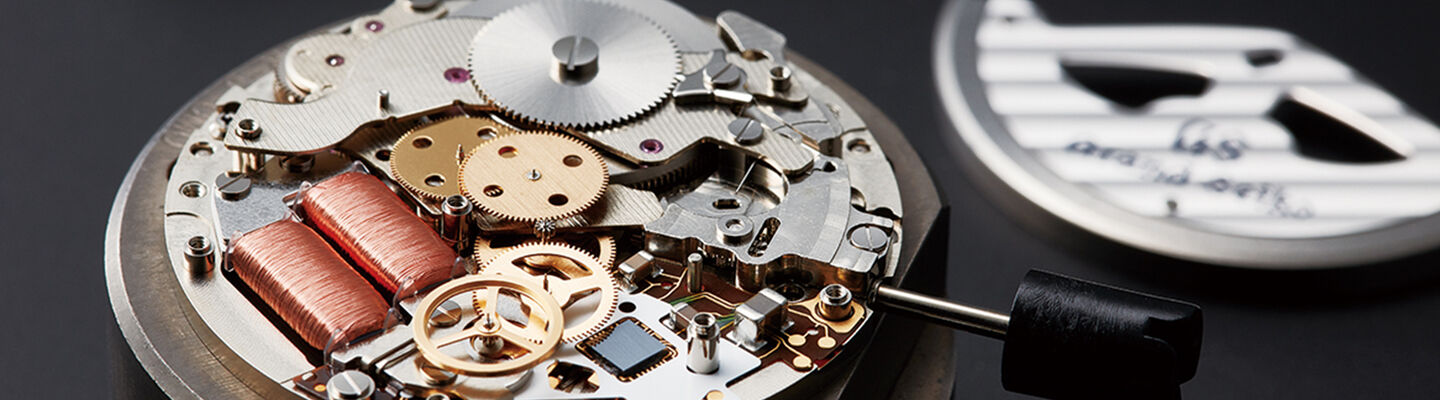 Close-up of a Grand Seiko watch movement during servicing, showing intricate mechanical components and precision engineering